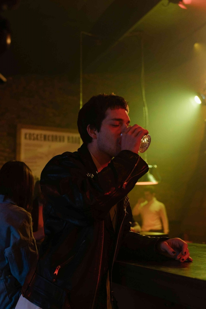 A Man in Black Leather Jacket while Drinking (Pexels/cottonbro studio)