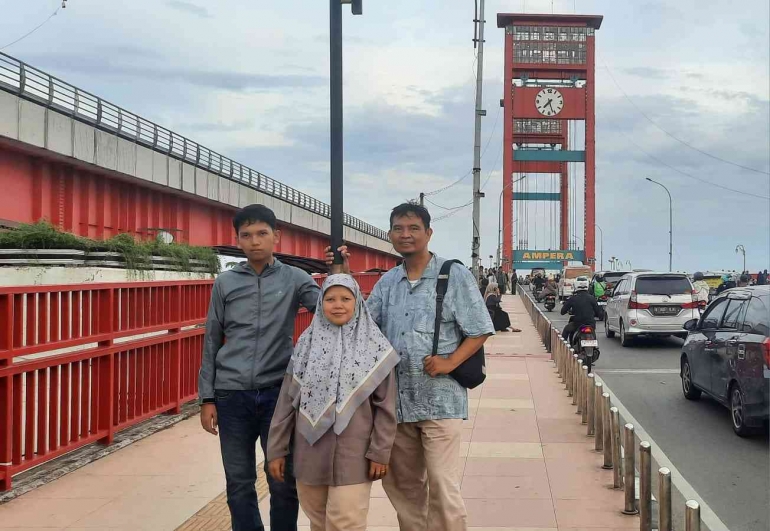Bersama suami dan ananda berfoto di Jembatan Ampera (dokpri)