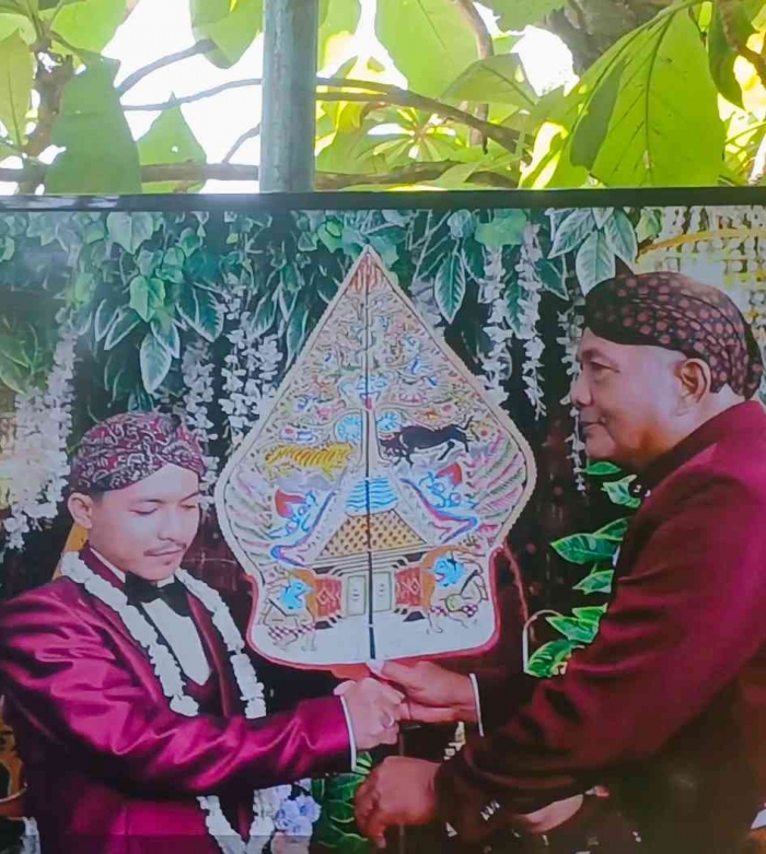 Gunungan diserahkan sebagai simbol kedudukan kepala keluarga (dokumentasi pribadi: Isti Yogiswandani)