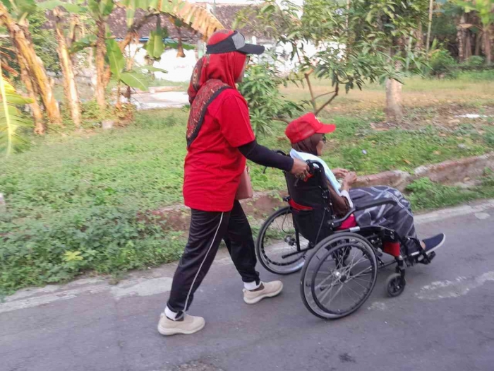 Adik Tarti mendorong kursi roda (dokpri)