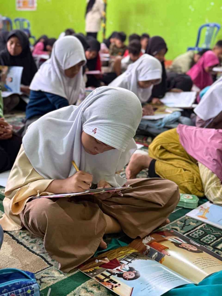 Seorang Peserta sedang menulis ulasan buku (Dokumentasi KKN Tematik)