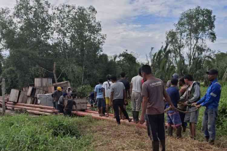 Petugas PLN dan warga bahu membahu membangun jaringan listrik di pelosok Pelangiran, Indragiri Hilir, Riau (26/9/2024). (KOMPAS.COM/IDON)