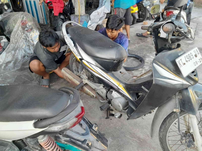 Dua anak bengkel mengganti ban dalam belakang (dokpri)