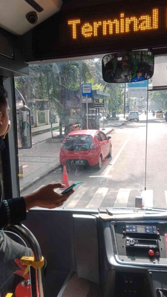 Kondektur menempatkan posisi bus dengan halte. - (Dokumentasi Pribadi)