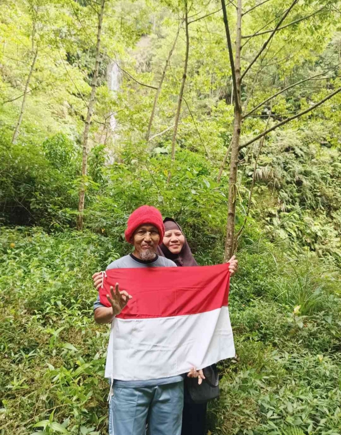 Yang putih itu air terjunnya. Dari kejauhan terlihat kecil, tapi gemuruh air menunjukkan aliran air yang dashyat (Dokpri: Isti Yogiswandani)