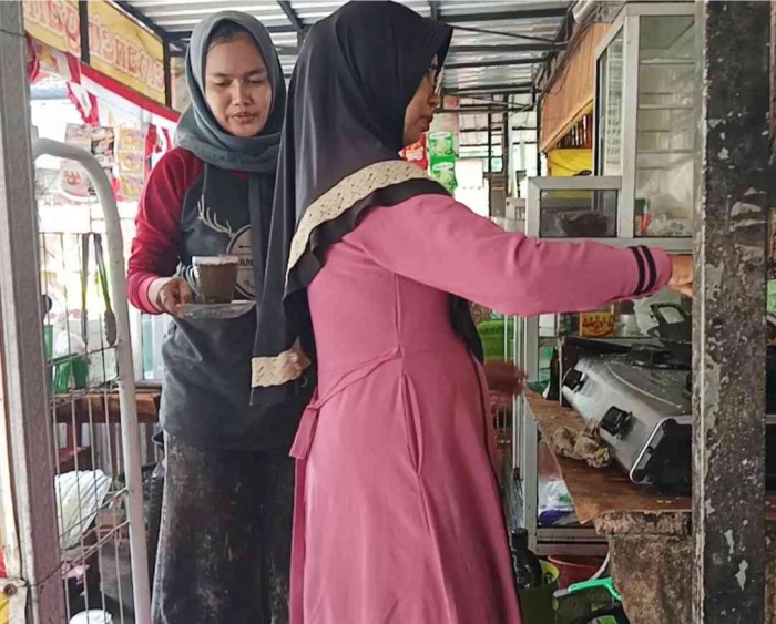 Bu Lis sedang menggoreng nila sambil mengajak saya ngobrol (Dokumentasi pribadi: Isti Yogiswandani)