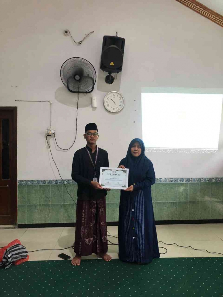 penyerahan sertifikat oleh ketua KKM 72 UIN Malang kepada Ustadzah TPQ Baitul Jannah
