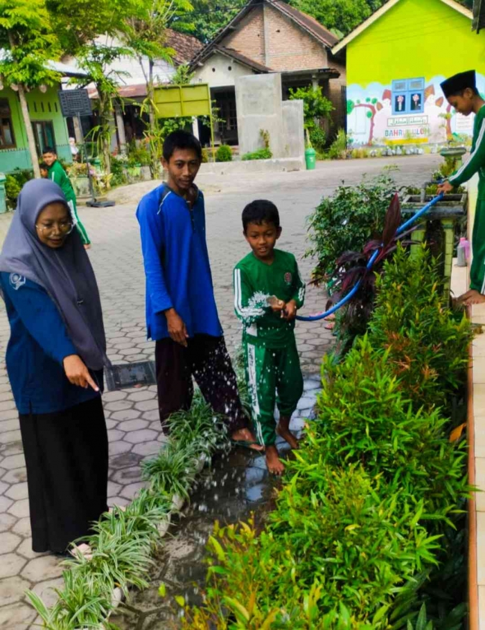 Warga sekolah menyiram tanaman dan membersihkan lingkungan sekolah (Dokumentasi MI Bahrul Ulum Buluh)