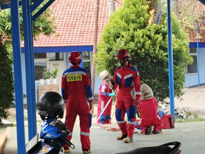 Petugas pemadam kebakaran sedang melakukan pembakaran pada sarang tawon. (Sumber foto: Jandris_Sky)