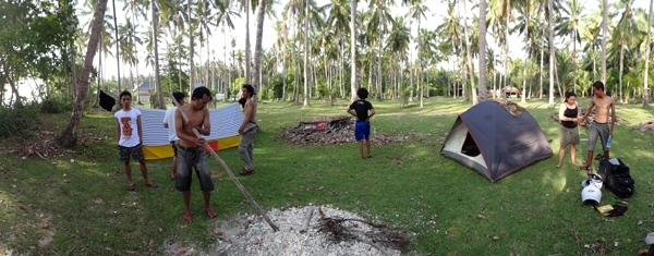mendirikan tenda di kebun kelapa dekat pantai