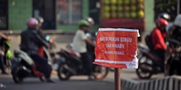 Pengendara motor melewati SPBU yang memasang tanda berisikan BBM bersubsidi habis di Jakarta, Selasa (26/8/2014). Kelangkaan BBM mulai muncul di beberapa daerah menyusul wacana kenaikan harga BBM karena komsumsi BBM melebihi batas maksimal 46 juta kiloliter. (AFP PHOTO / BAY ISMOYO)