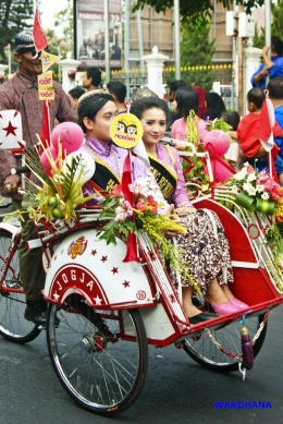 Dimas dan Diajeng menaiki becak wisata yang dihias dengan aneka bunga