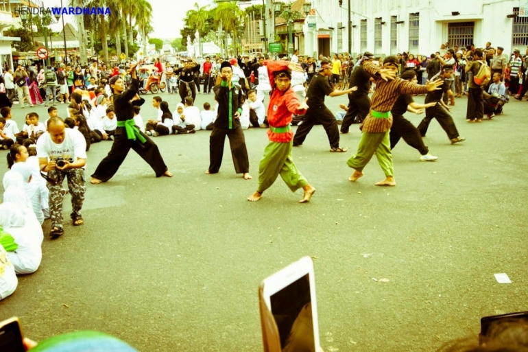 Peragaan jurus dalam Rampak Pencak di perempatan Nol Kilometer bersamaan dengan perayaan Hari Pariwisata Dunia 2014.
