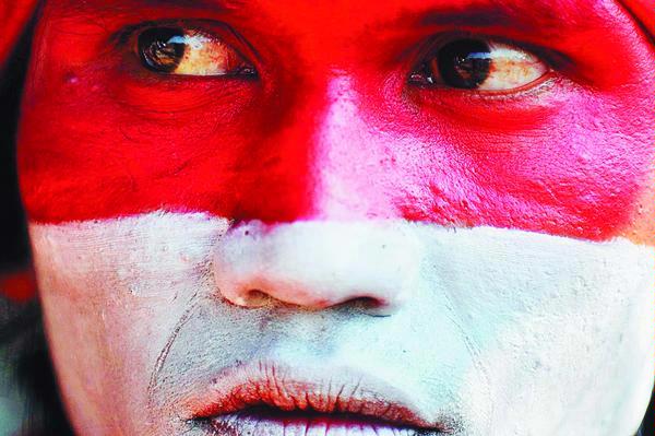 Peserta upacara peringatan Hari Kemerdekaan Ke-64 RI di Stadion R Maladi, Sriwedari, Solo, Jawa Tengah, Senin (17/8), mengecat wajahnya dengan warna merah putih. (KOMPAS/HERU SRI KUMORO)