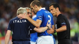 Giorgio Chiellini (C) of Italy is treated for an injury during the UEFA EURO 2012 final against Spain