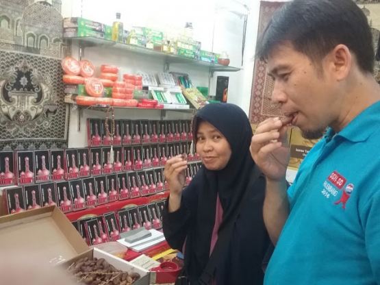 Ibu Ellina dan suami, member relawan literasi, sedang mencicipi kurma di toko Putera Kudus. (Foto: Doel)