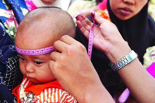 Anak balita yang tengah diukur lingkar kepalanya untuk mengetahui perkembangan tubuhnya di Puskesmas Bantul 1, Palbapang, Bantul, DI Yogyakarta (Kompas.com)